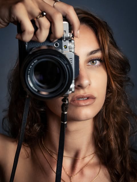 Photographe tenant son appareil devant son visage